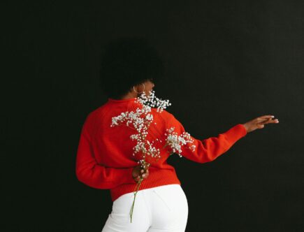 graceful ethnic model with white flower behind back