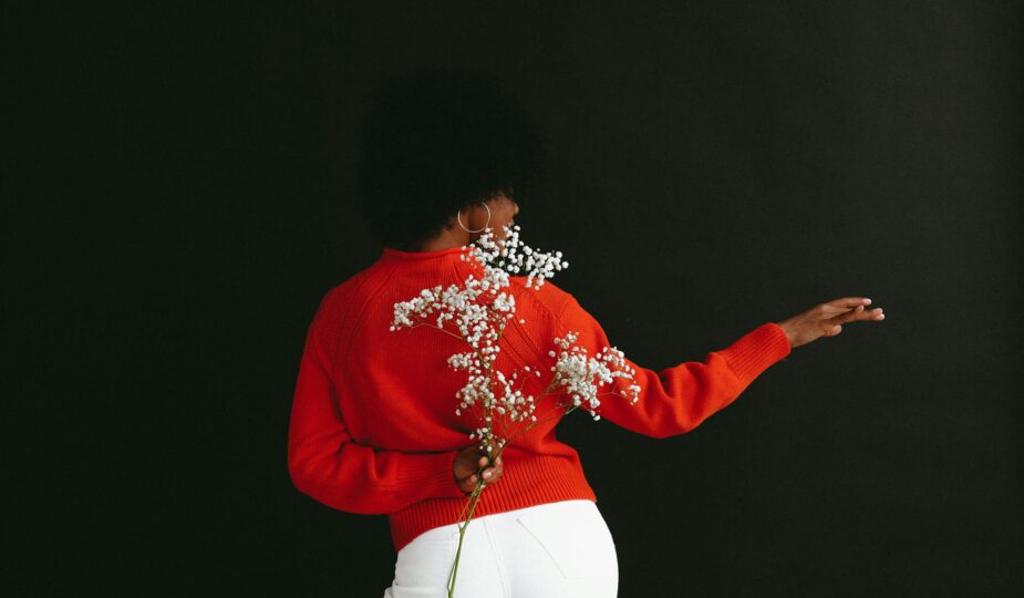 graceful ethnic model with white flower behind back